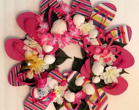 One of our favorite flip flop crafts is the flip flop wreath, and now that summer stuff is back on the shelves it's the perfect time to make one! Here is my version of the flip flop wreath, embellished with fake flowers and some other summery items.
